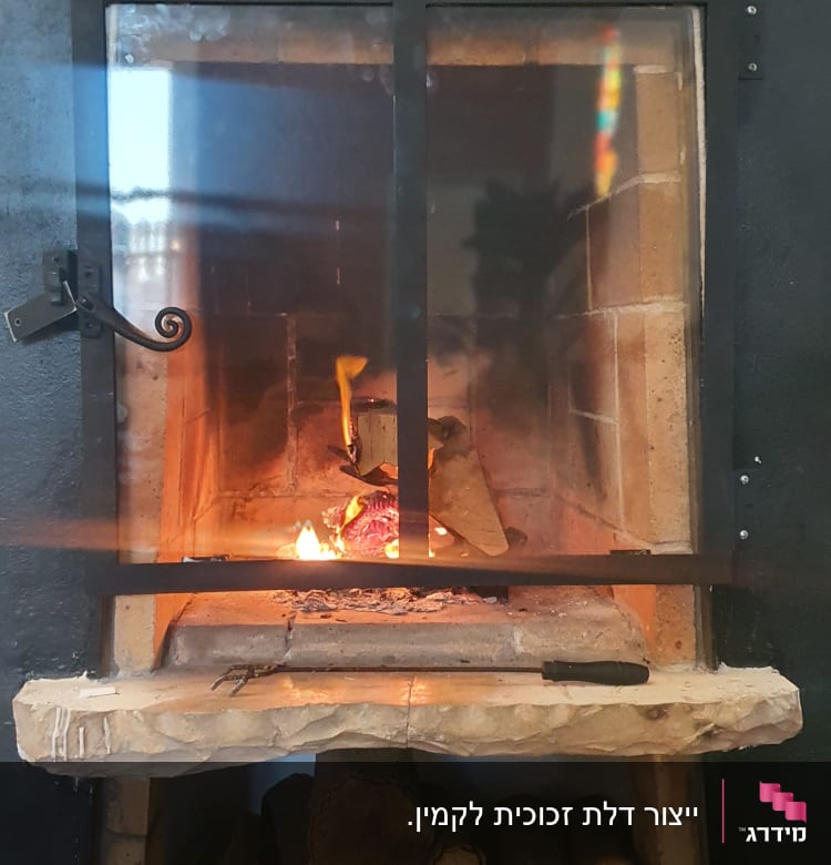 מסגרת מתכת שחורה סביב אח עם אש בוערת